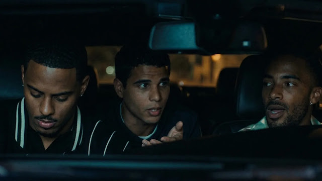 Three friends sitting in a car at night in The Gates