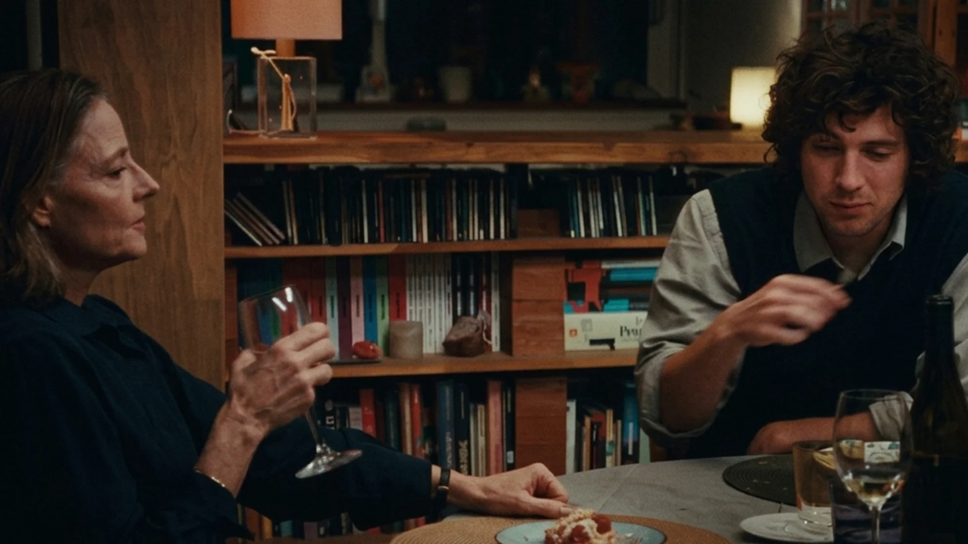 Jodie Foster as Lilian Steiner and Vincent Lacoste as her son Julien at a book lined table in A Private Life