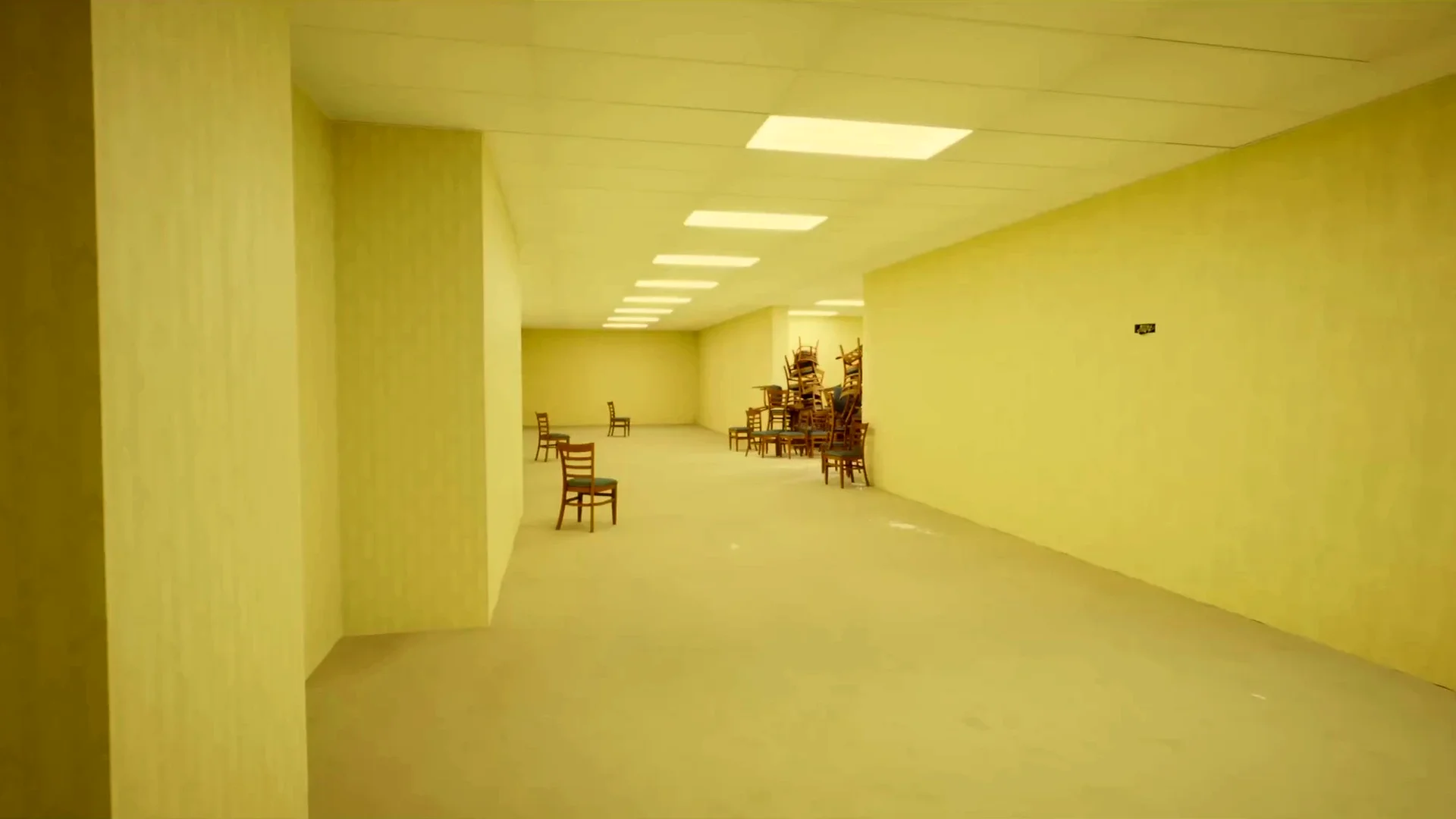 An empty room in the Backrooms stretches into the distance under rows of fluorescent lights, with a cluster of chairs at its center