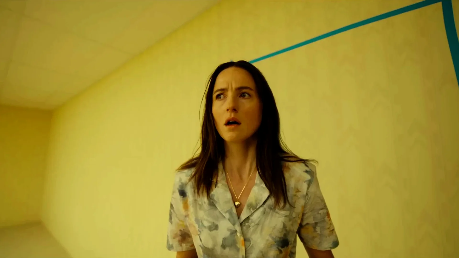 Mary (Renate Reinsve) stares upward in alarm in a yellow-walled room