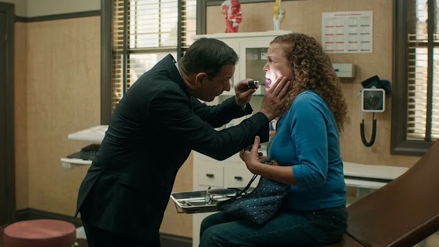 Dr. Martin Best examines a patient's throat with a penlight in his clinic in Best Medicine