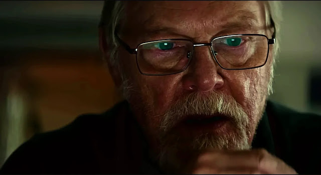 Alfred Berg (Peter Andersson), a retired detective in glasses, lit low at night in Blood Sacrifice