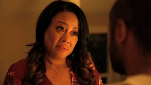 Monica White (Lela Rochon) in a warm-lit close-up, facing someone across from her