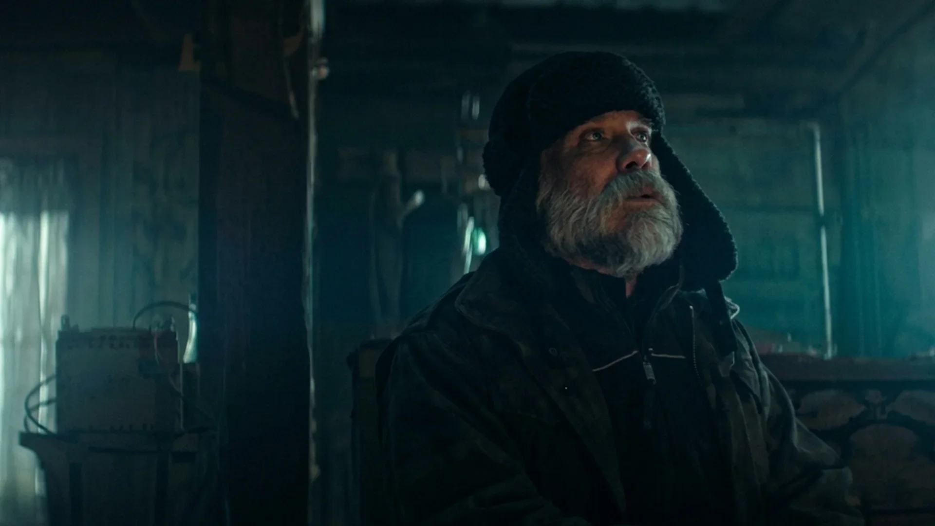 One of the kidnappers waits in the dim light of the remote cabin in Dead of Winter