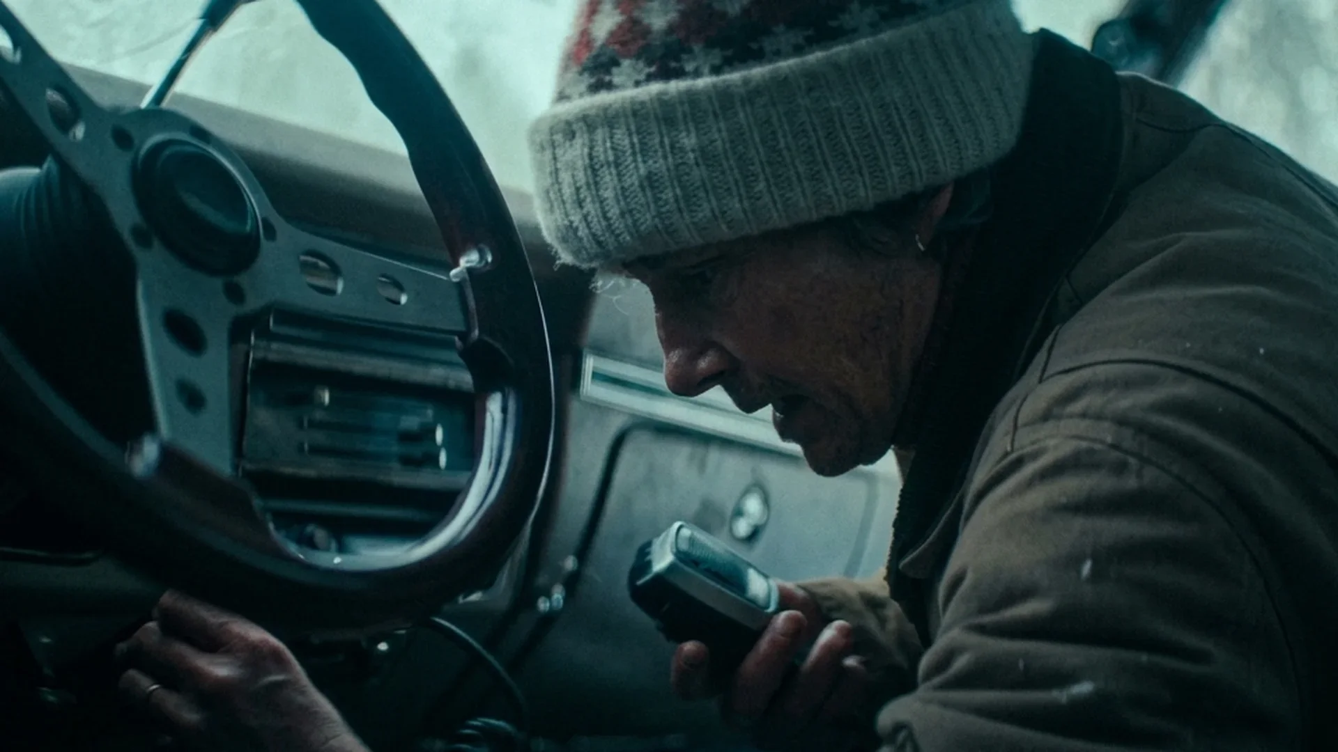 Barb hunches over her van's dashboard, improvising, in Dead of Winter