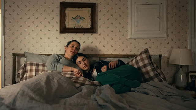 Elizabeth (Melanie Lynskey) and her daughter Sophie lying close together on a bed