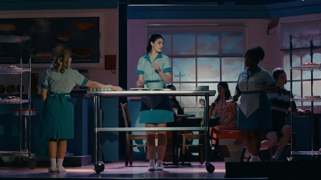 Sophie (Sunny Sandler) performing on a brightly lit stage set dressed as a 1950s diner in Don't Say Good Luck