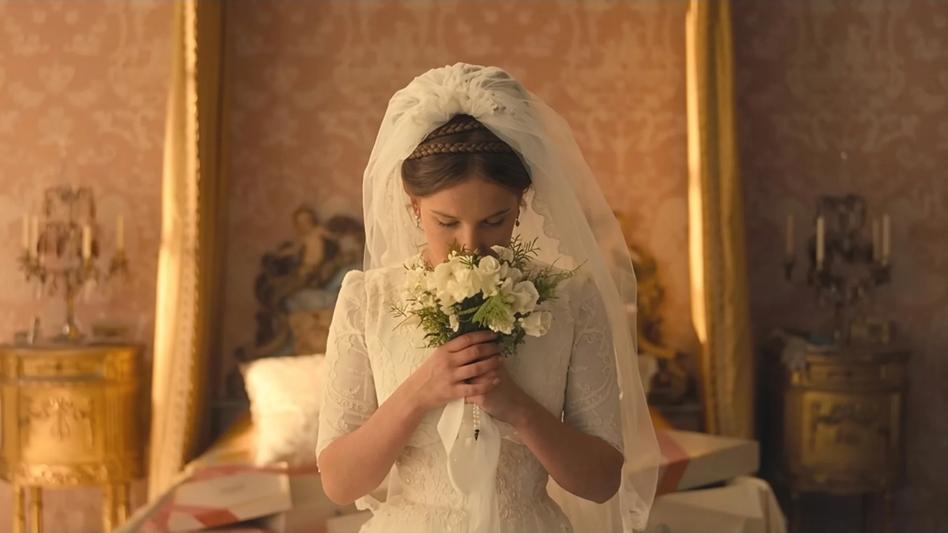 Enola Holmes as a bride, holding a bouquet to her face, looking pensive before the ceremony