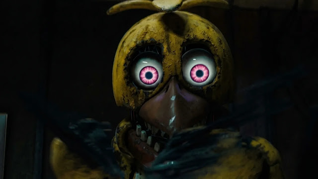 A worn Toy Chica animatronic with glowing pink eyes stares in the dark in the Five Nights at Freddy's 2 trailer