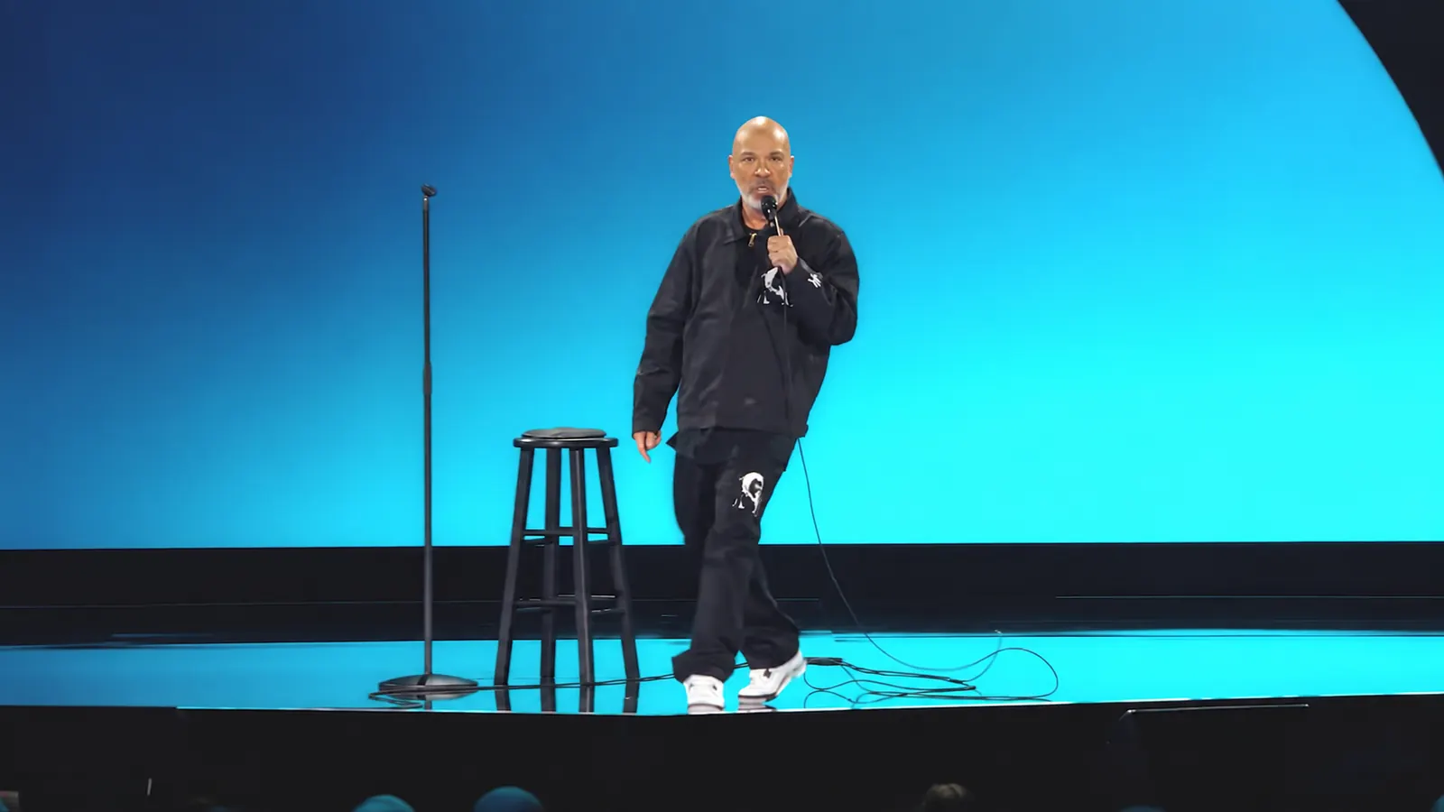 Jo Koy speaks into a microphone during Netflix's Blue in the Face