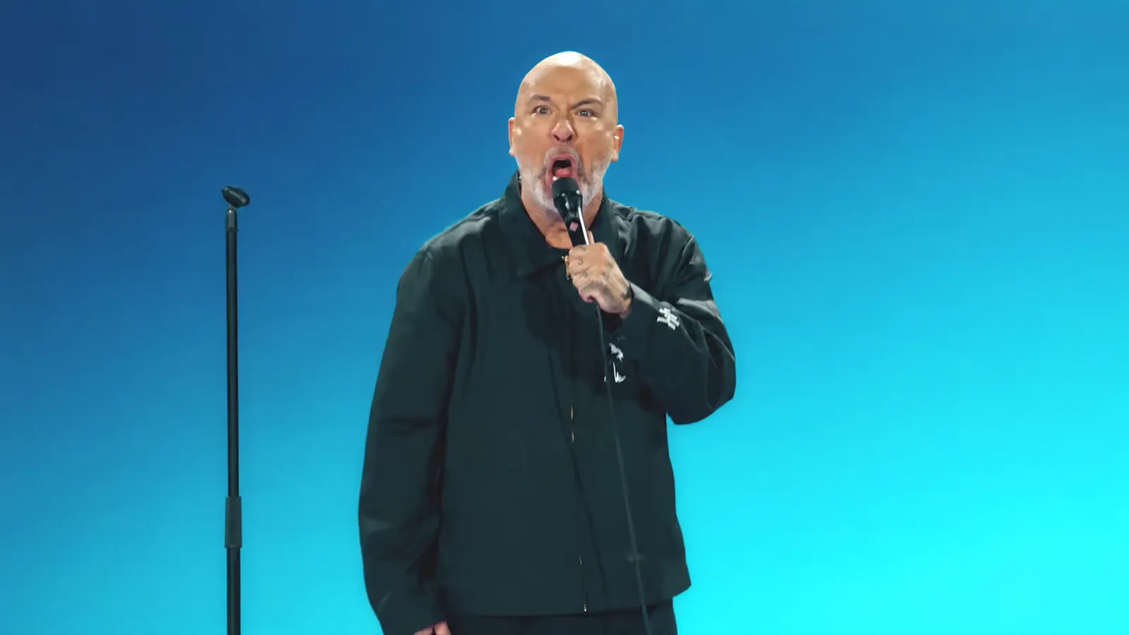Jo Koy reacts into a microphone during his Blue in the Face performance