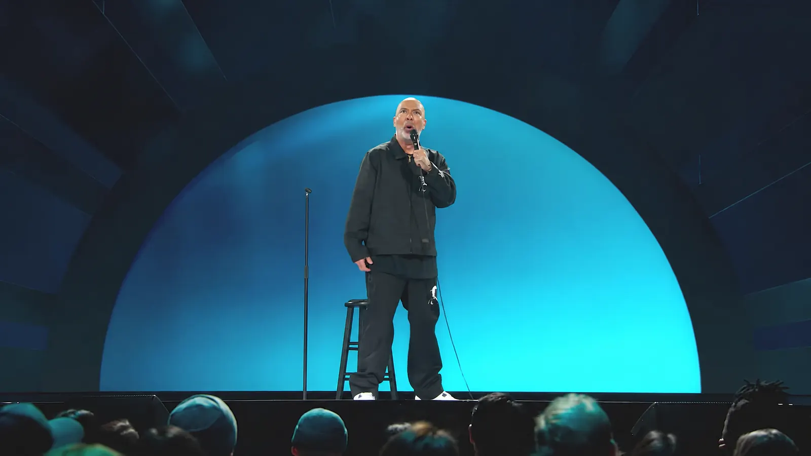 Jo Koy stands beneath the blue arch of the Blue in the Face stage