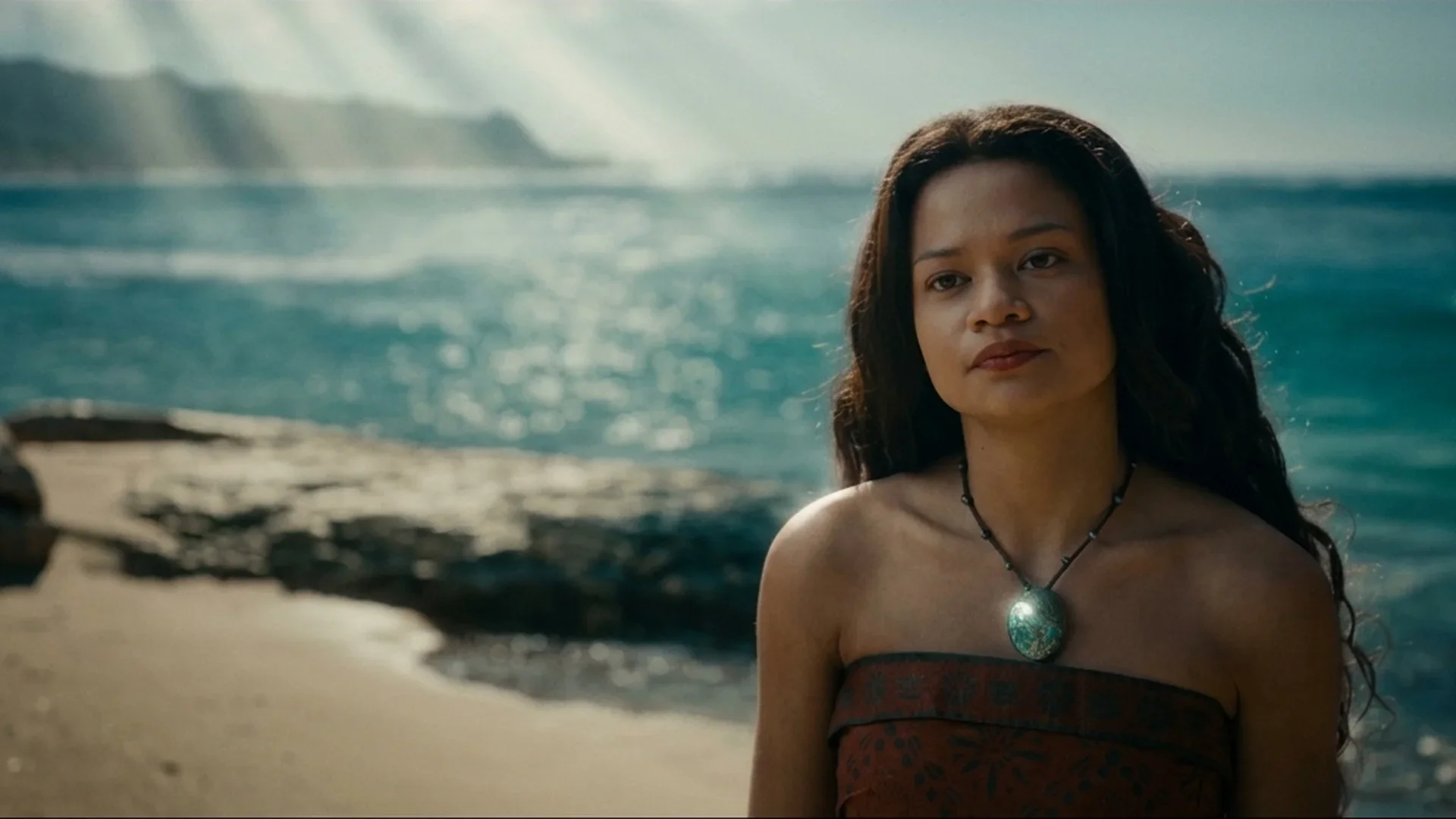 Catherine Laga'aia as Moana stands at the shoreline in a close-up from Disney's live-action Moana