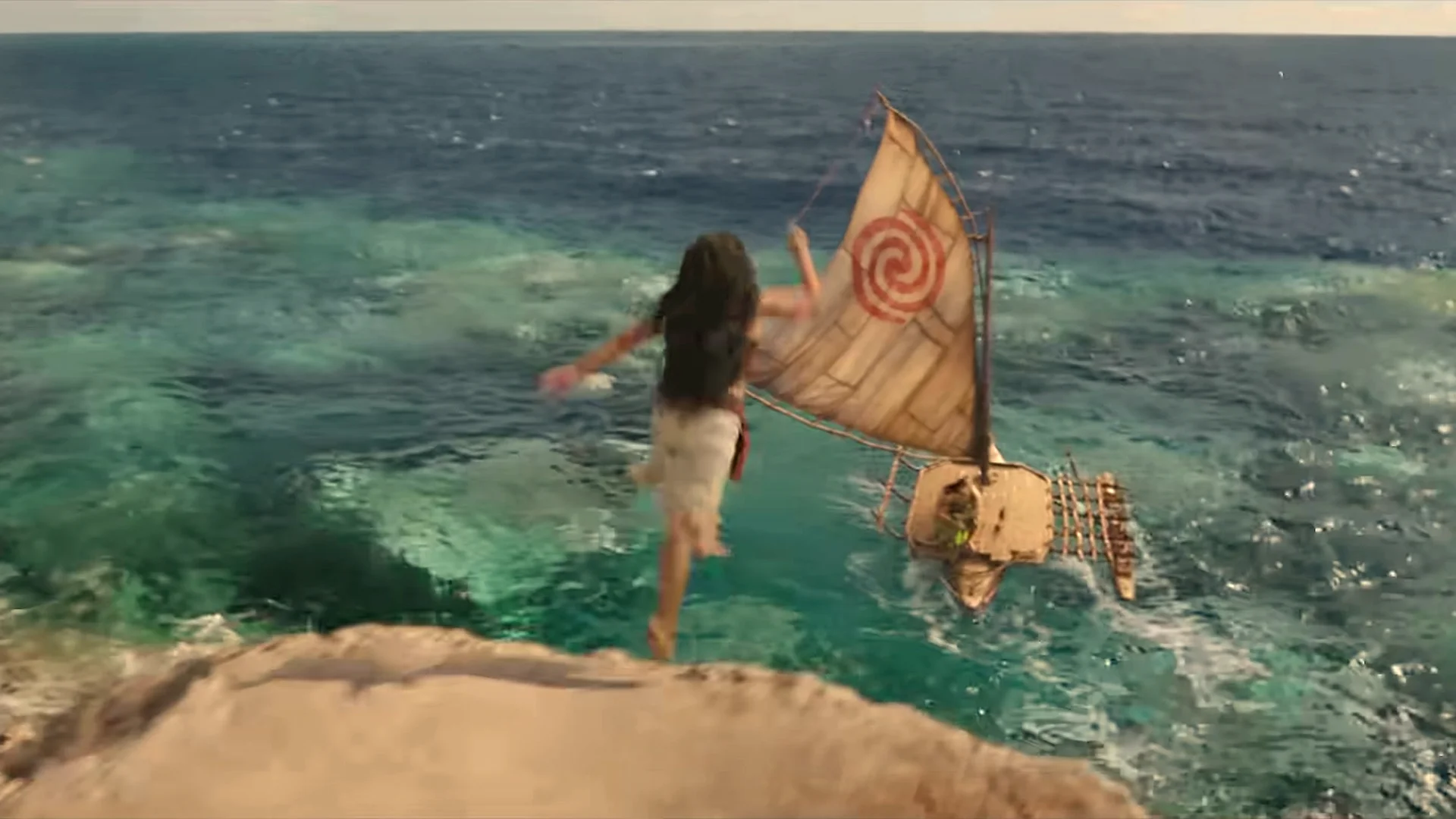Aerial shot of Moana leaping toward her canoe over turquoise reef water in the live-action Moana trailer