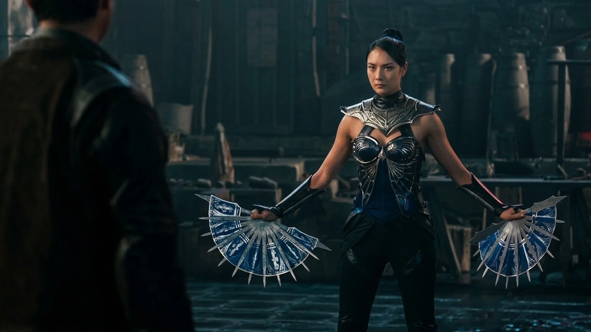 Kitana, in dark armor, holds her two steel fans spread wide, ready to fight