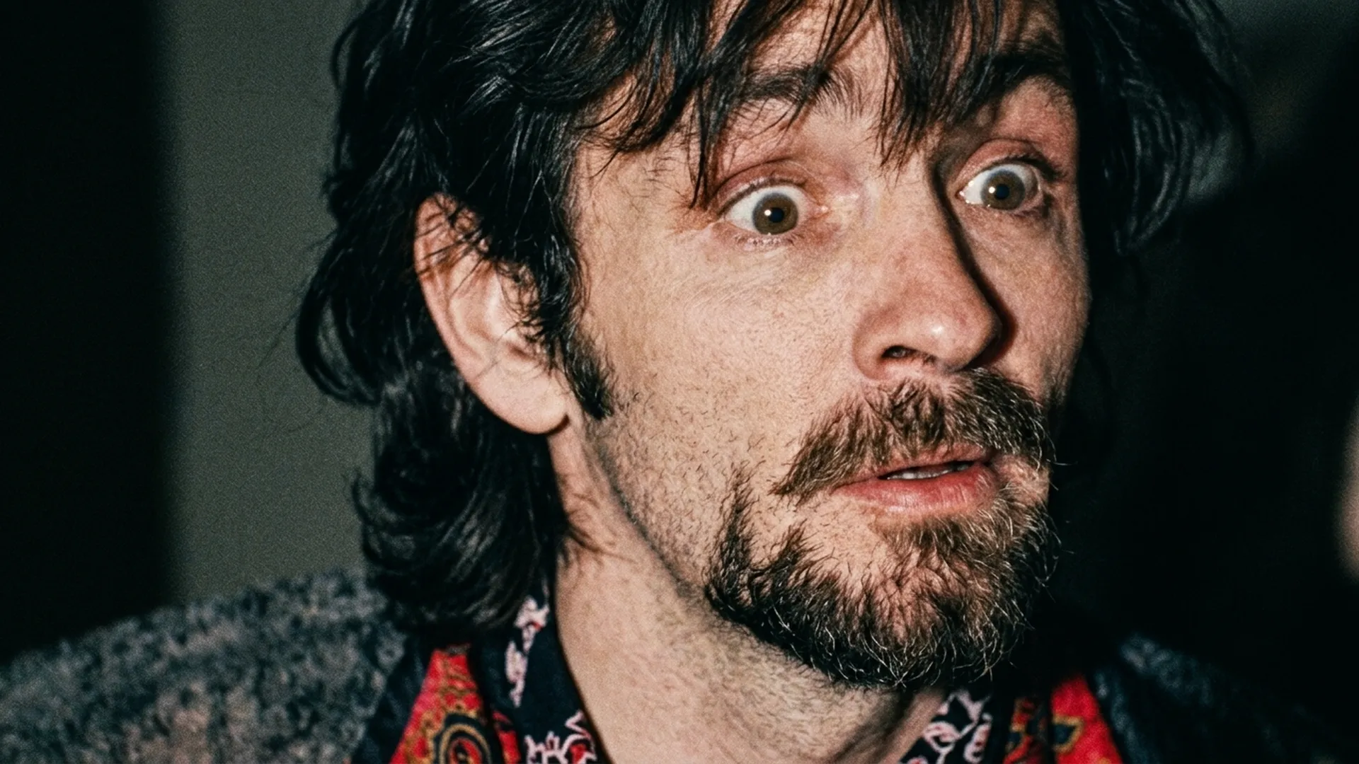 Archival footage of Charles Manson staring wide-eyed toward the camera