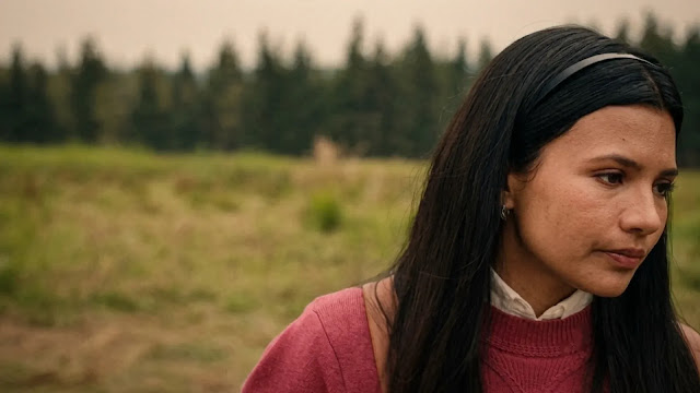 Jackie Howard stands outdoors on the ranch in My Life with the Walter Boys Season 3, forest and open fields behind her.