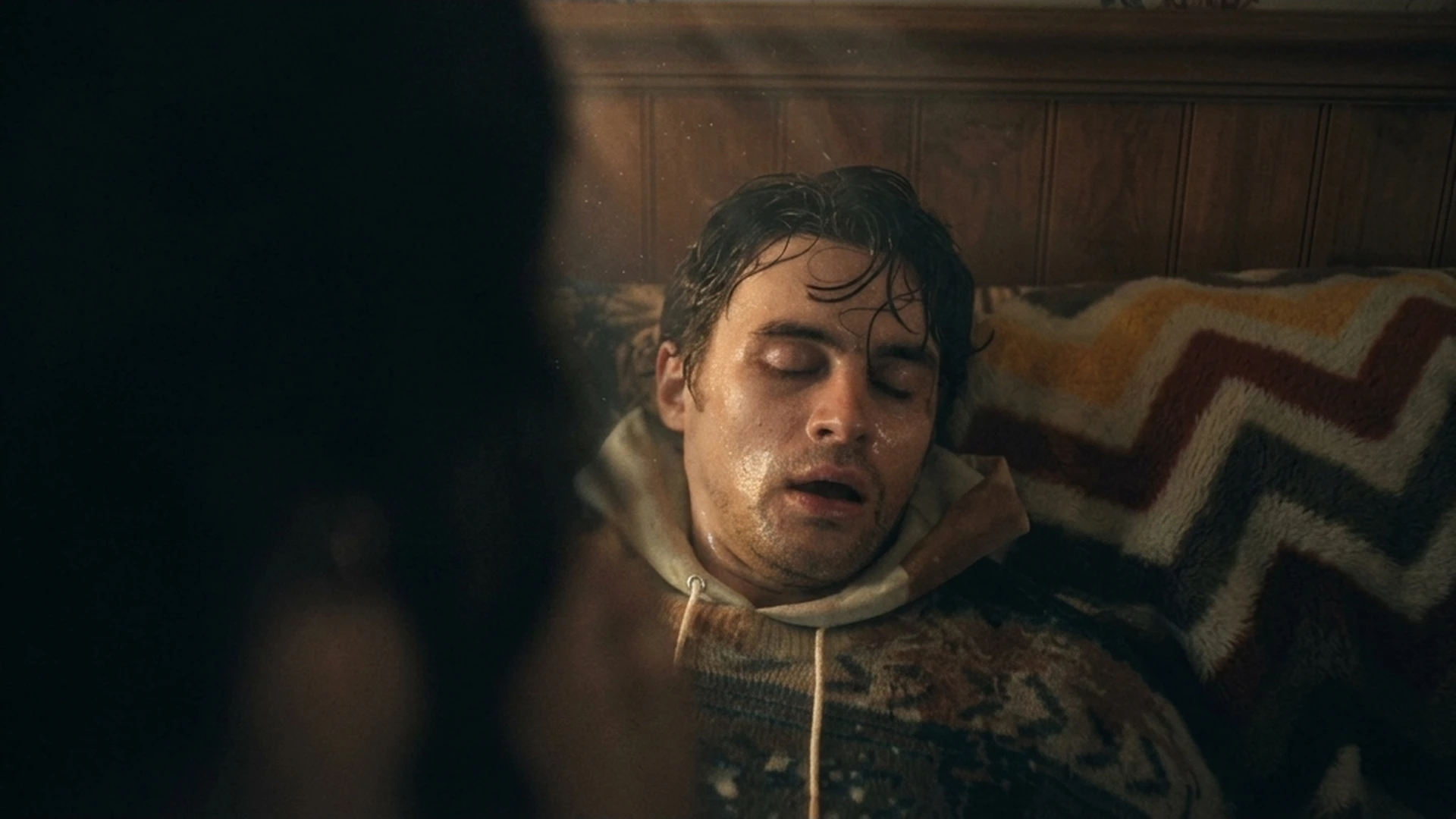 Bear (Michael Johnston) collapsed and unconscious as a figure leans over him in the Obsession trailer