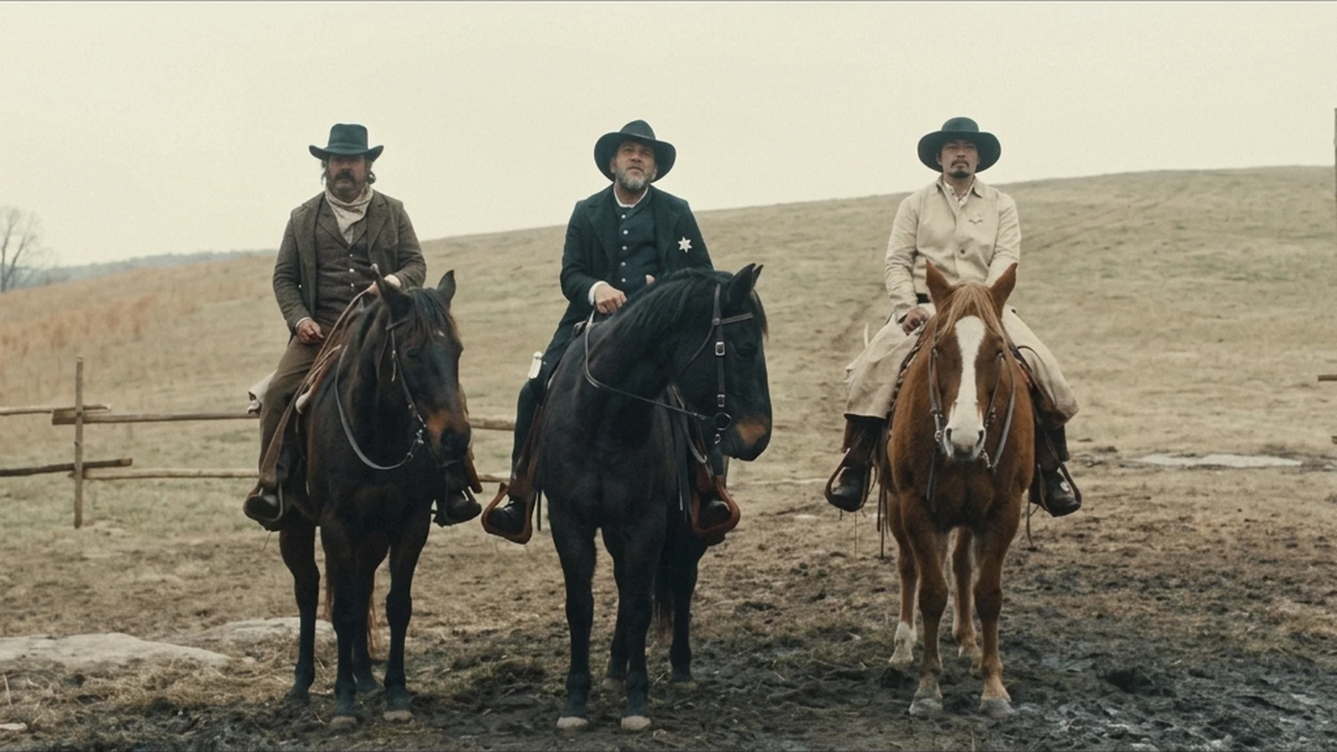 Three armed riders lined up on horseback before a ridge outside Henry's farm in the Old Henry trailer