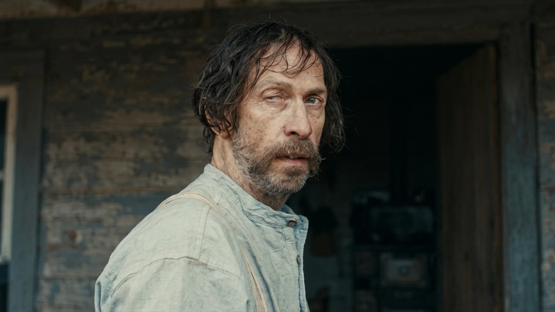 Tim Blake Nelson as Henry in profile outside his house, wary and guarded, in the Old Henry trailer