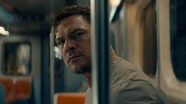 Jack Reacher riding a subway car, watchful, in Reacher Season 4