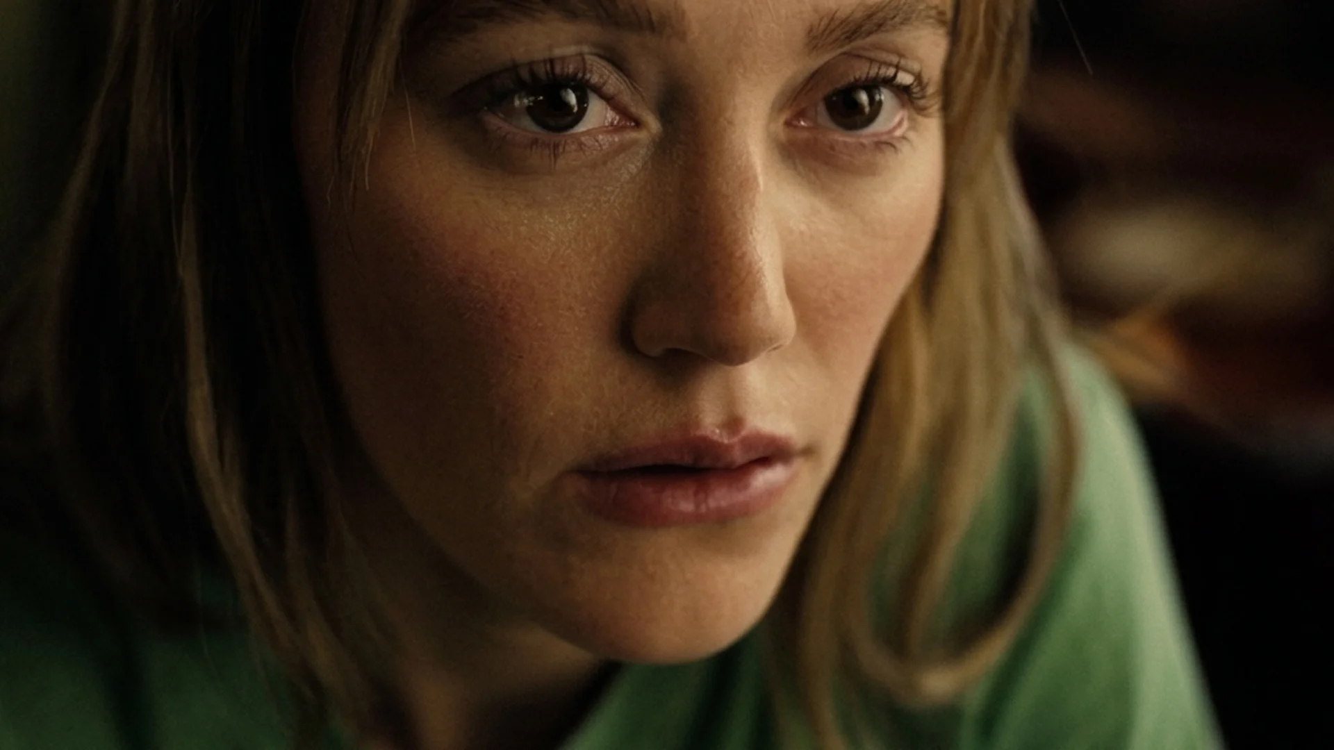 Maika Monroe as Kenna in a close-up, holding back tears in Reminders of Him