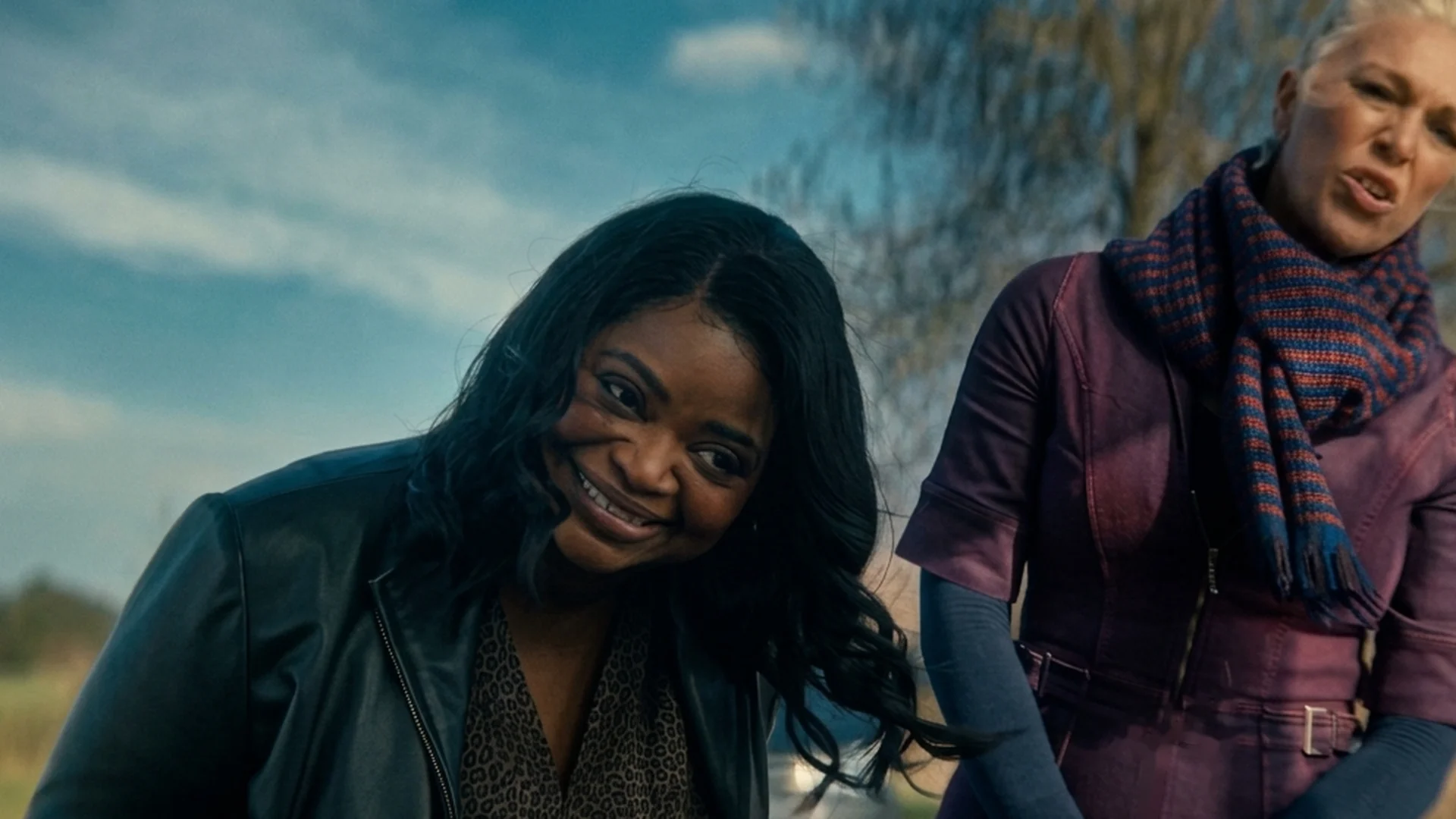Judith (Hannah Waddingham) and Debbie (Octavia Spencer) stand together outdoors in a field, Debbie grinning