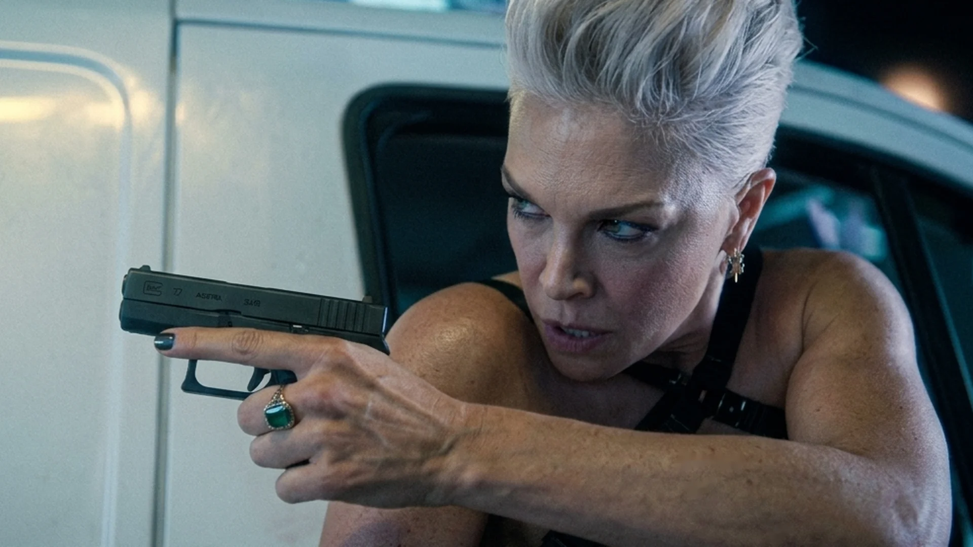 Judith (Hannah Waddingham) leans from a van window and aims a pistol