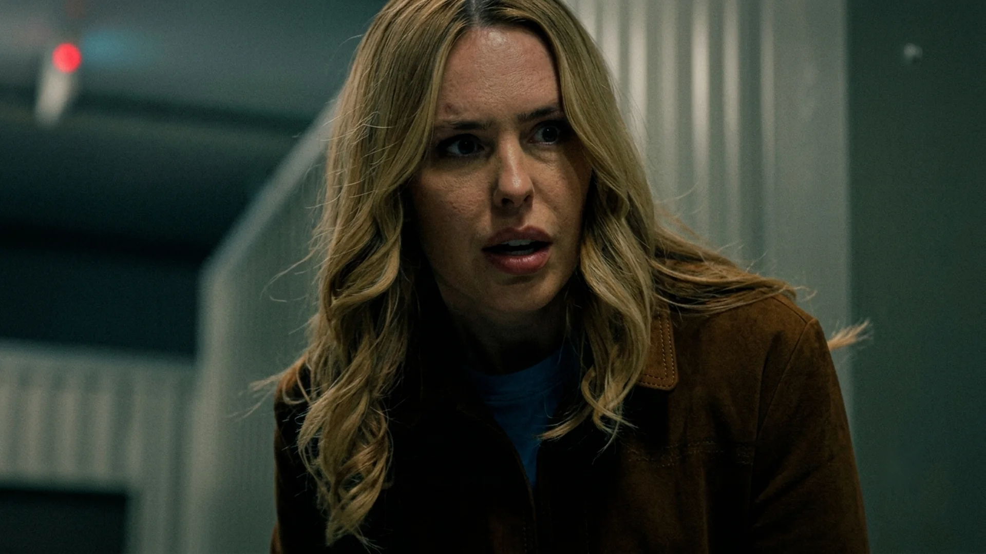 Amy reacts in shock inside the dim storage facility in The Body in the Locker