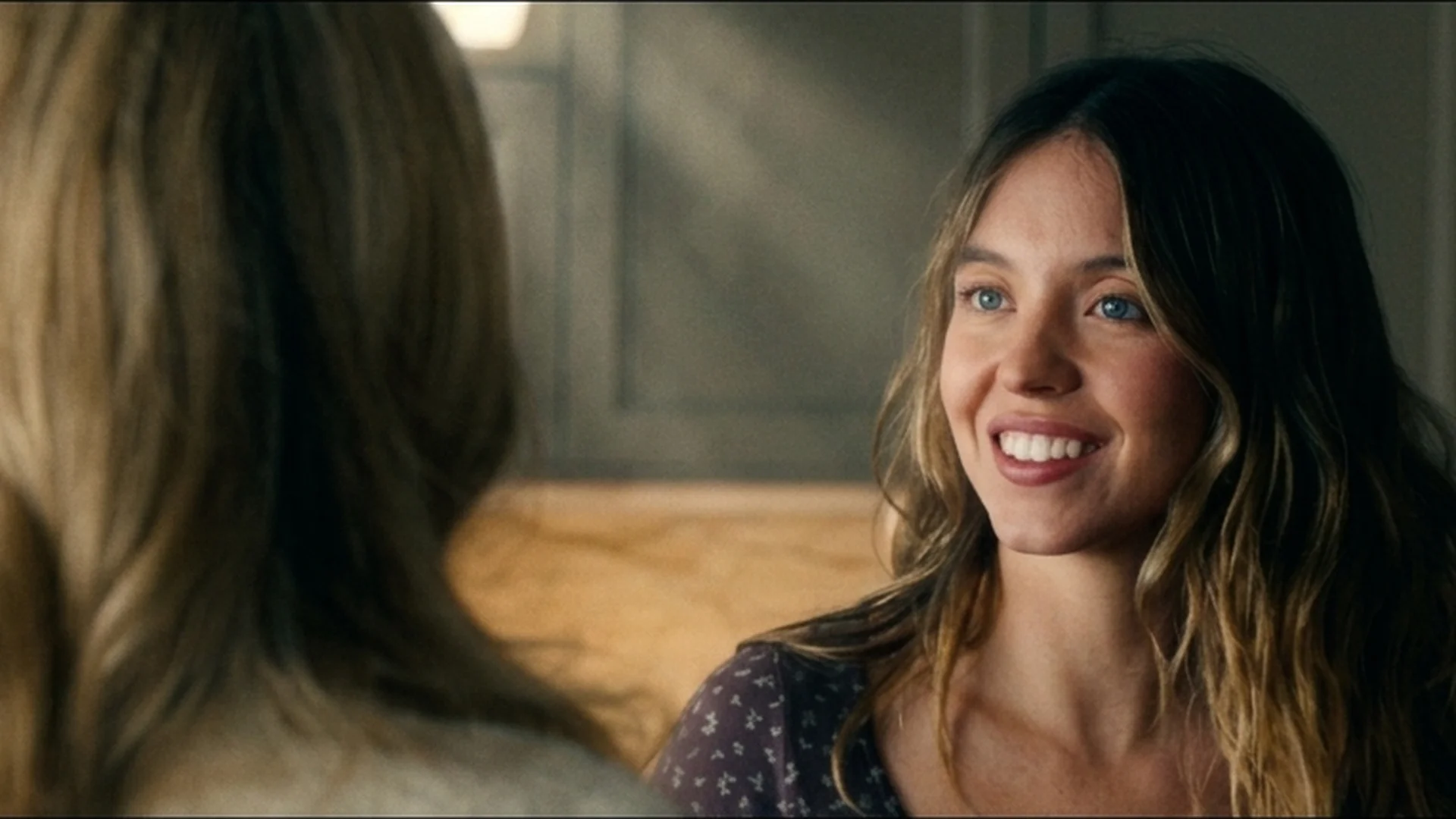Sydney Sweeney as Millie smiling in the Winchester kitchen in The Housemaid trailer