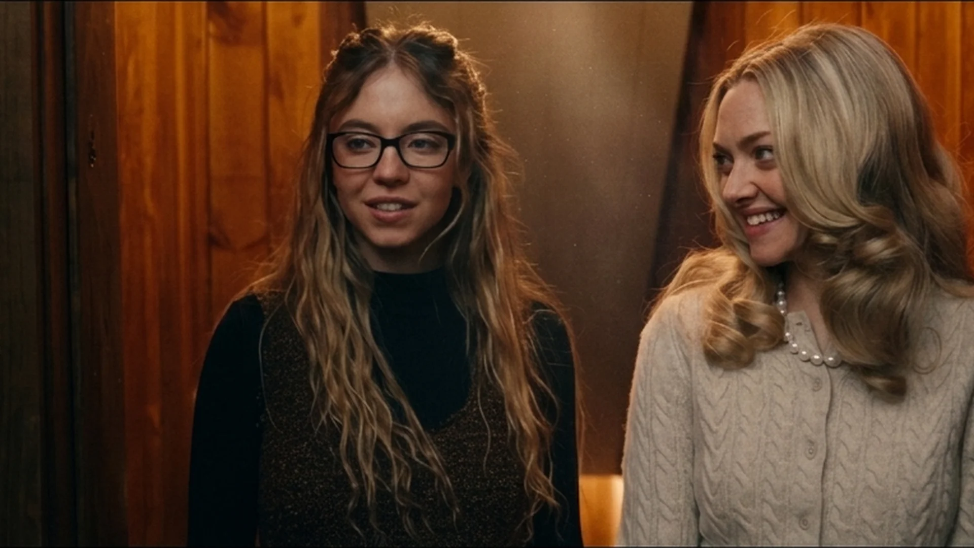 Amanda Seyfried as Nina sizing up Sydney Sweeney's Millie, in glasses, during the job interview in The Housemaid trailer