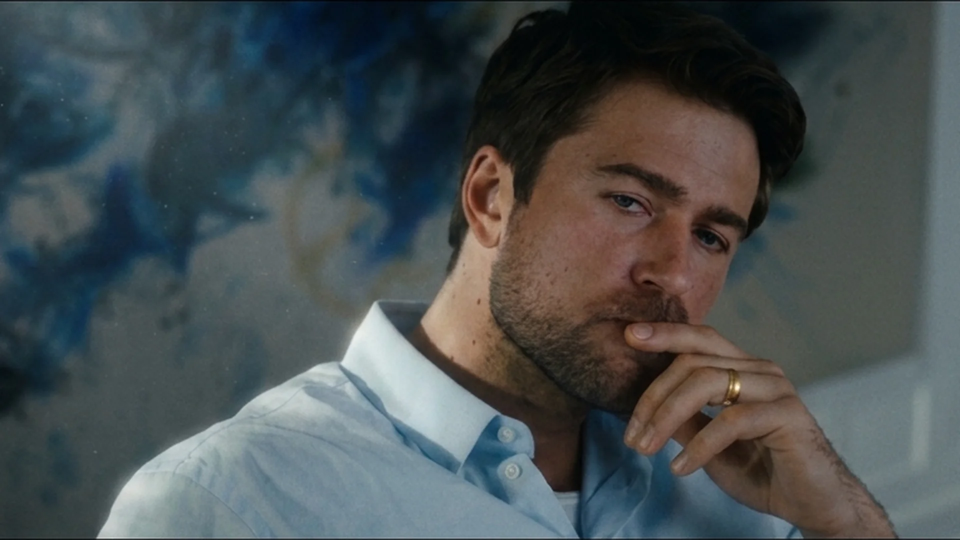Brandon Sklenar as Andrew Winchester in a white shirt, hand to his mouth, in The Housemaid trailer