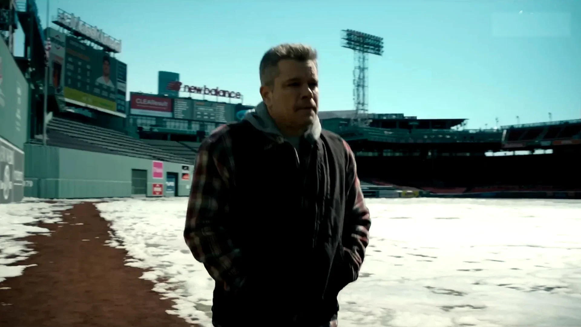 Rory (Matt Damon) walks alone through an empty, snow-dusted ballpark in the cold in The Instigators