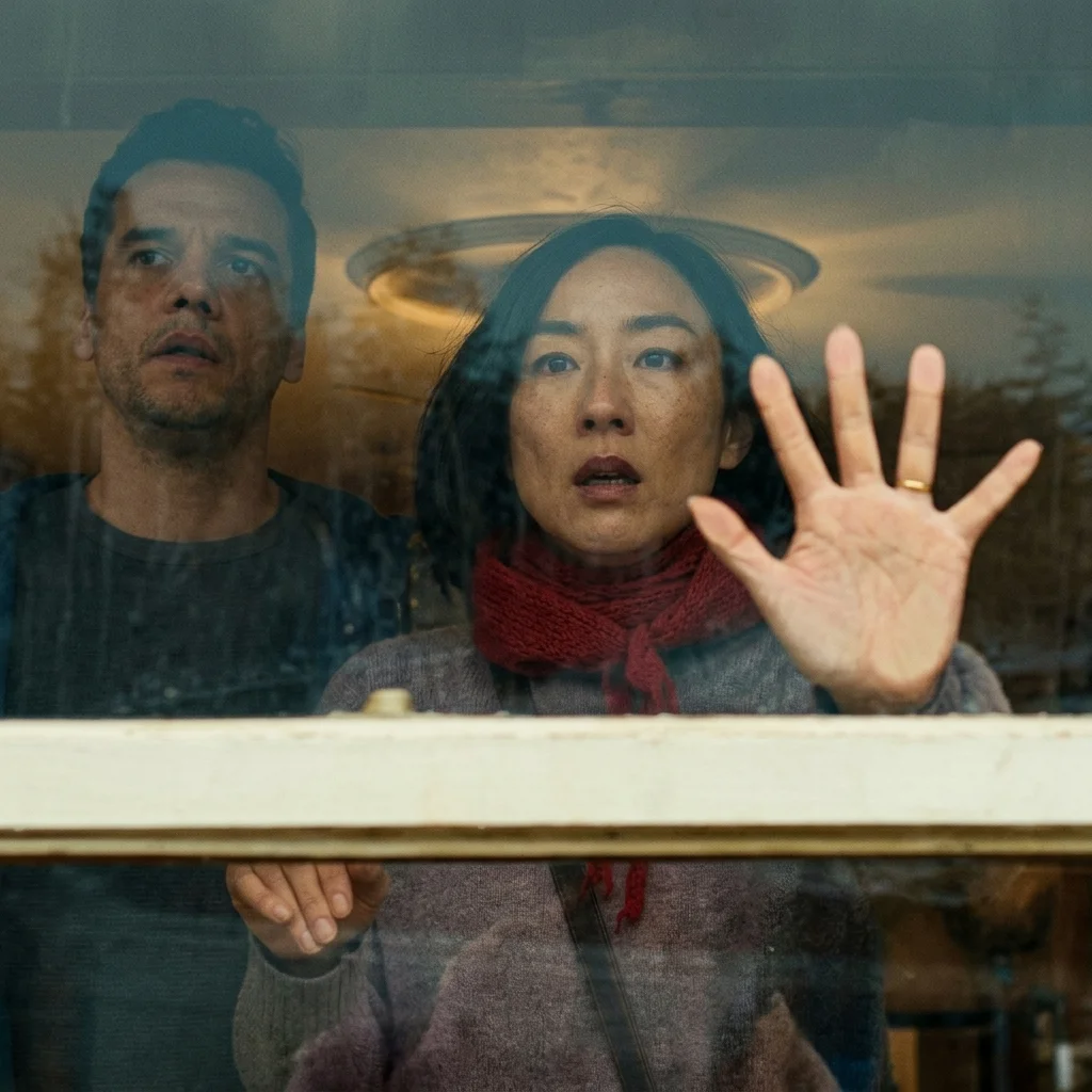 Wagner Moura as Jason lit by a window inside the house in The Last House