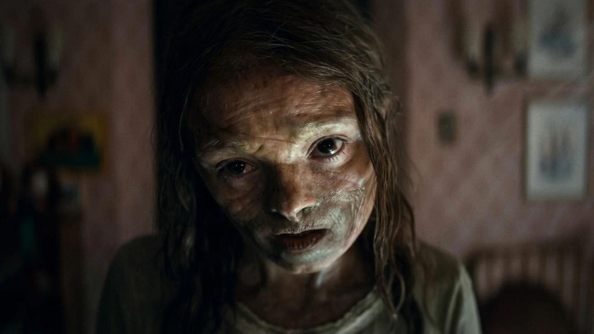 Katie, possessed and ashen-skinned, stares into the camera in a dim bedroom in Lee Cronin's The Mummy
