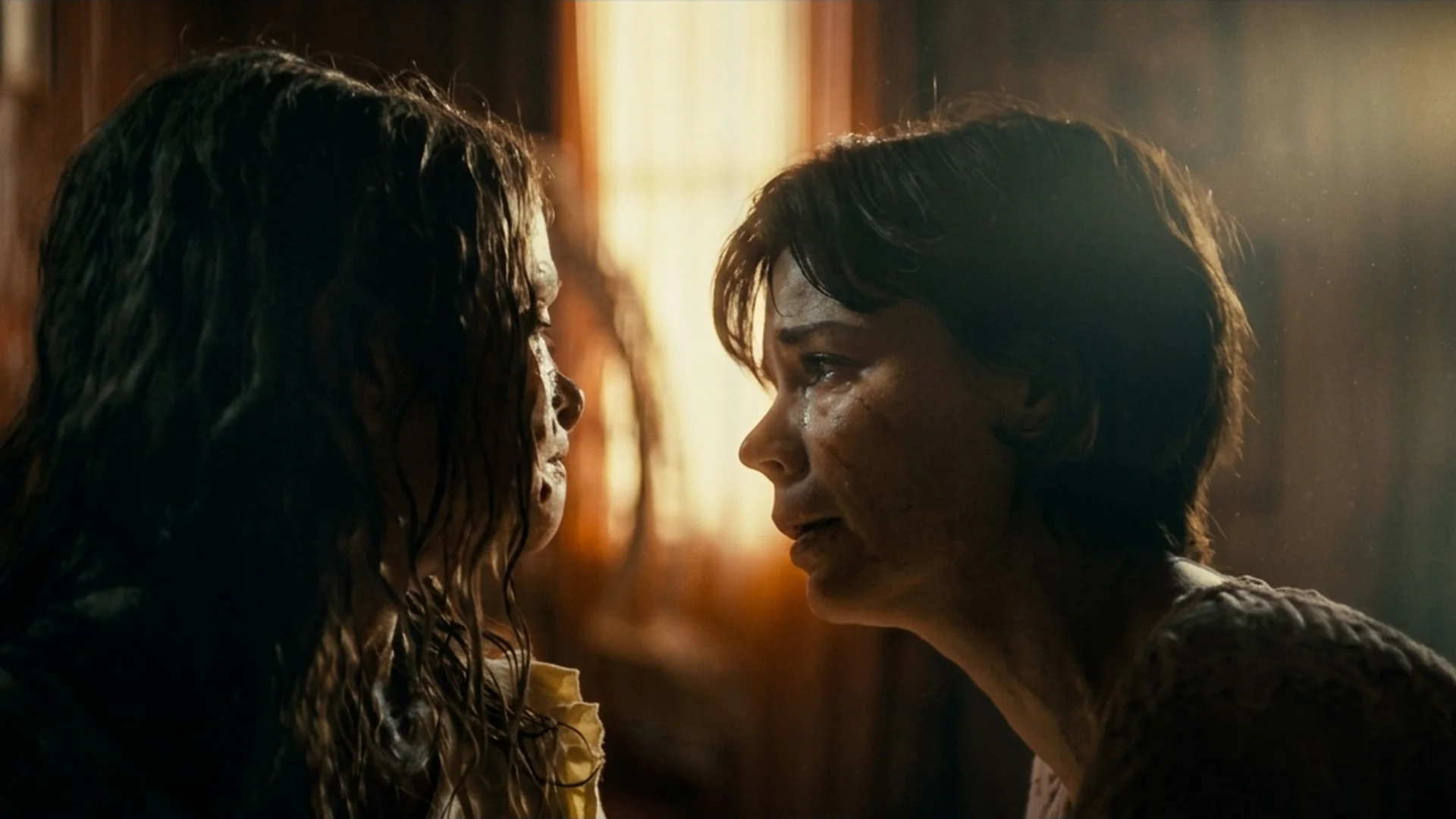Larissa leans close to her returned daughter Katie against a sunlit window in Lee Cronin's The Mummy