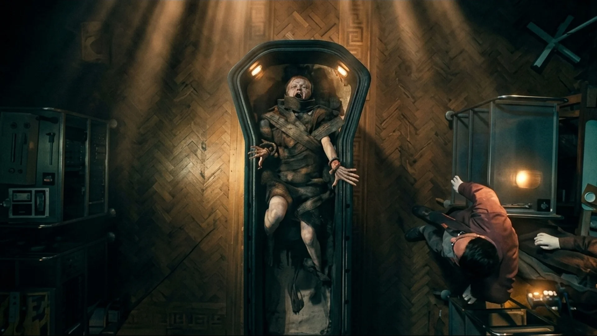 A mummified body sealed upright inside a coffin in a dim room in Lee Cronin's The Mummy