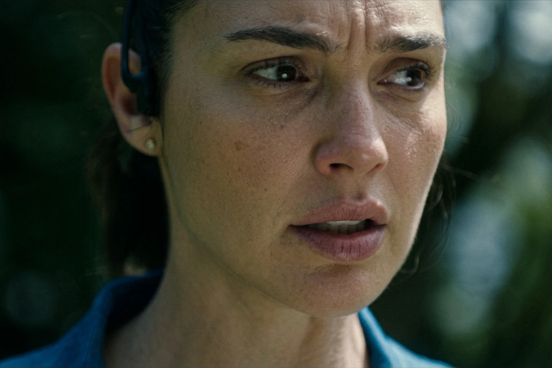 Maia Marten (Gal Gadot) listening to the Caller through her running earpiece in The Runner