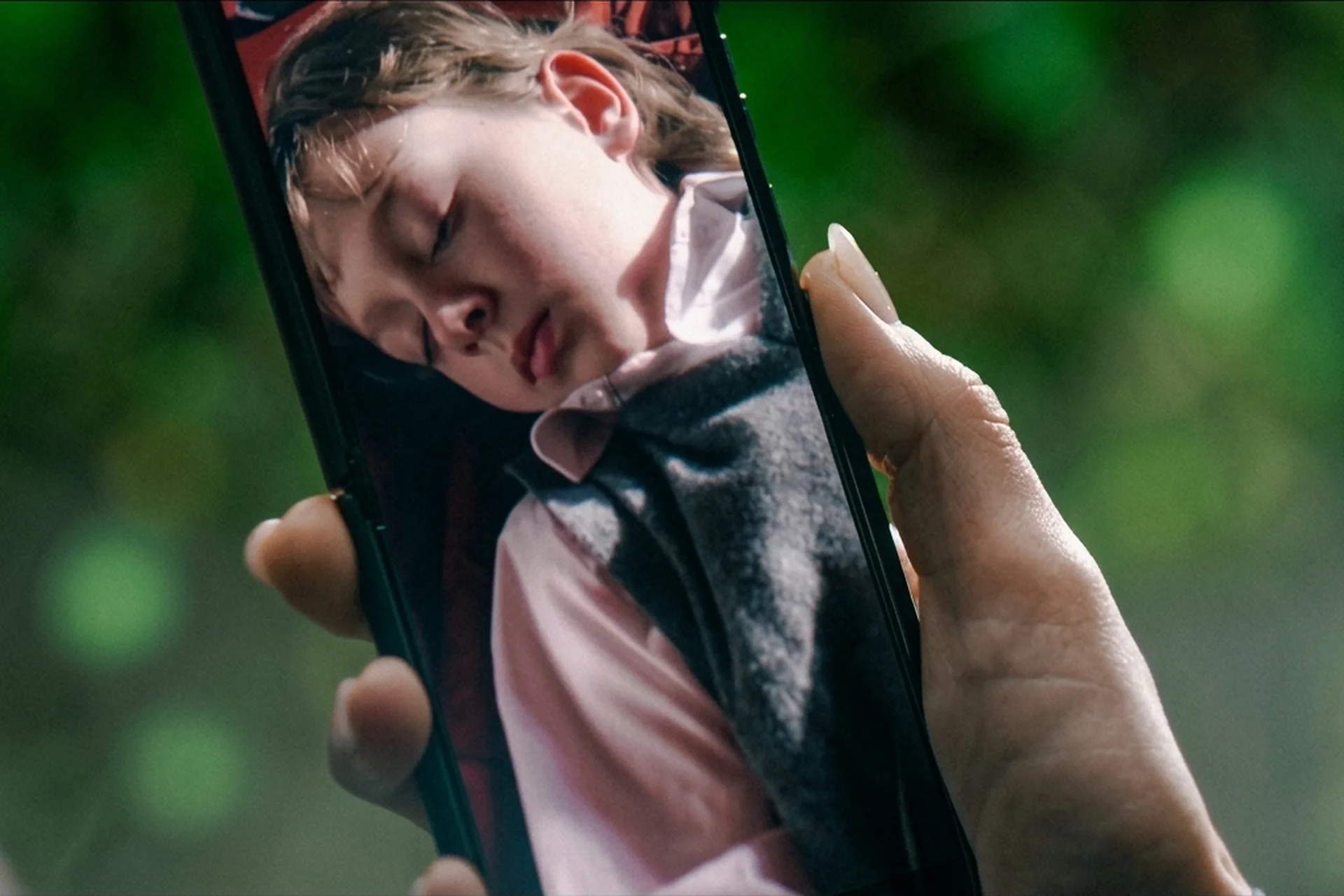 Maia's phone screen showing her son Noah slumped and unconscious in The Runner