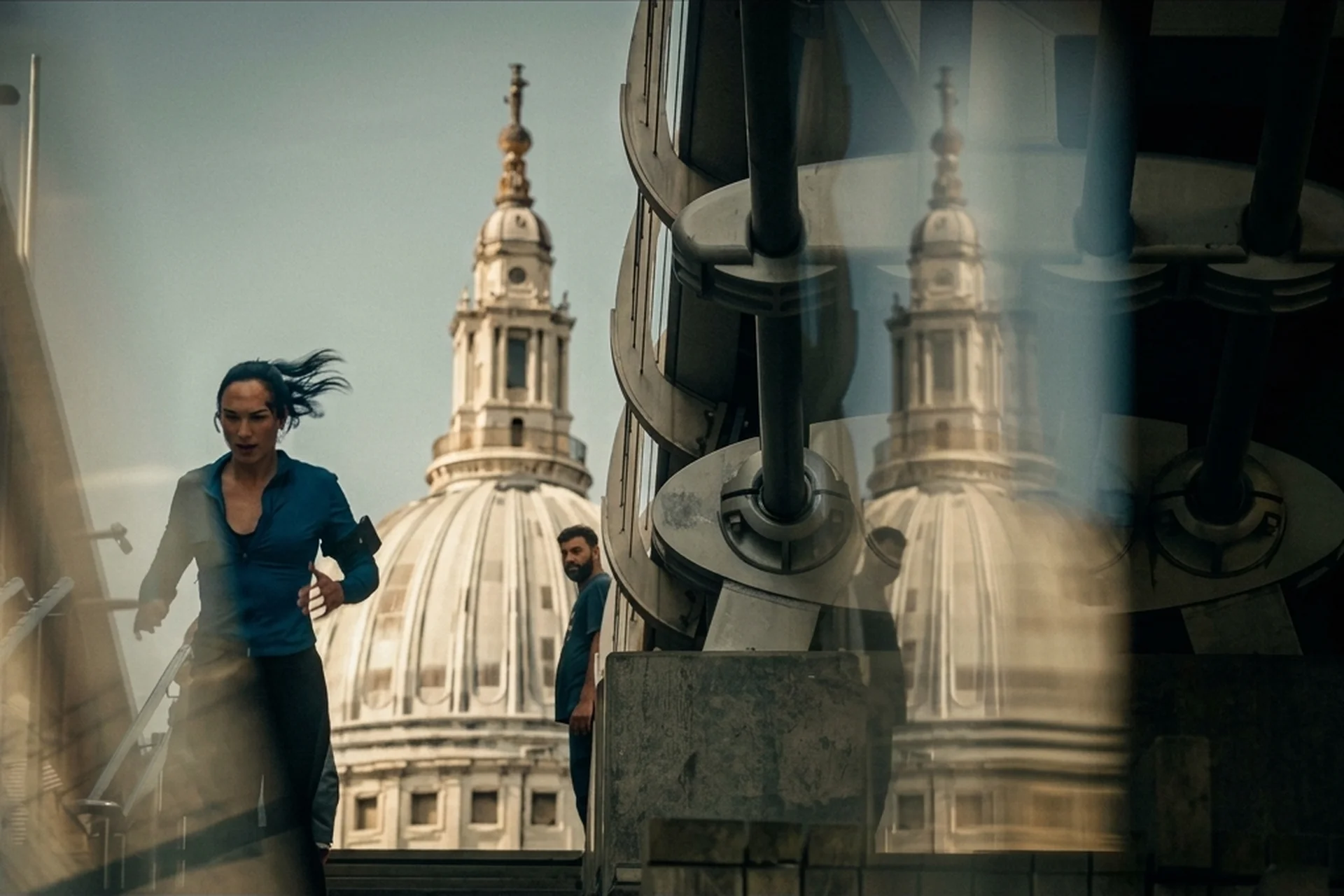 Maia running past the dome of St Paul's Cathedral, shot through glass, in The Runner