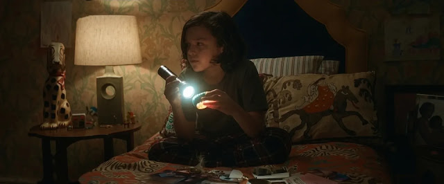Tom's young son Jake alone in bed at night with a flashlight in The Whisper Man
