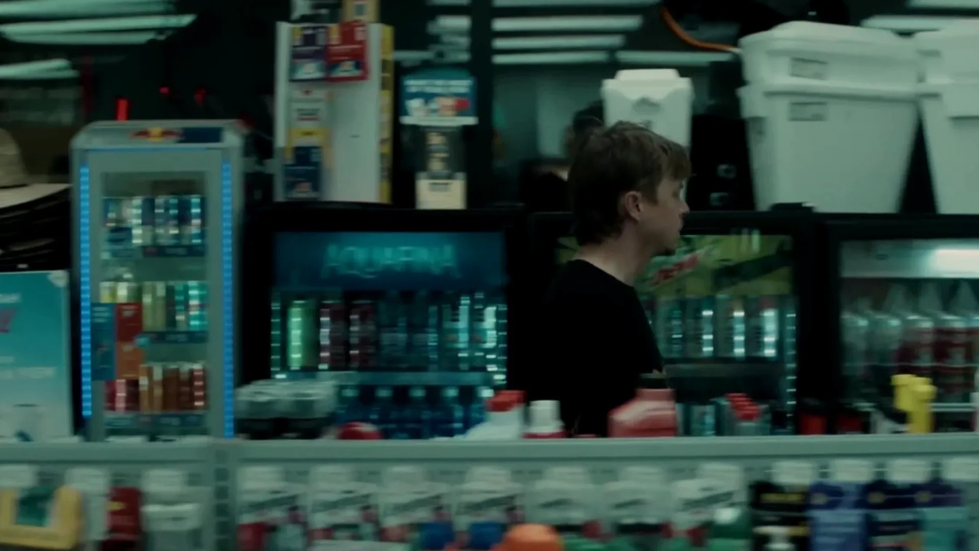 The interior of a convenience store at night, a figure moving among the shelves, in Wardriver